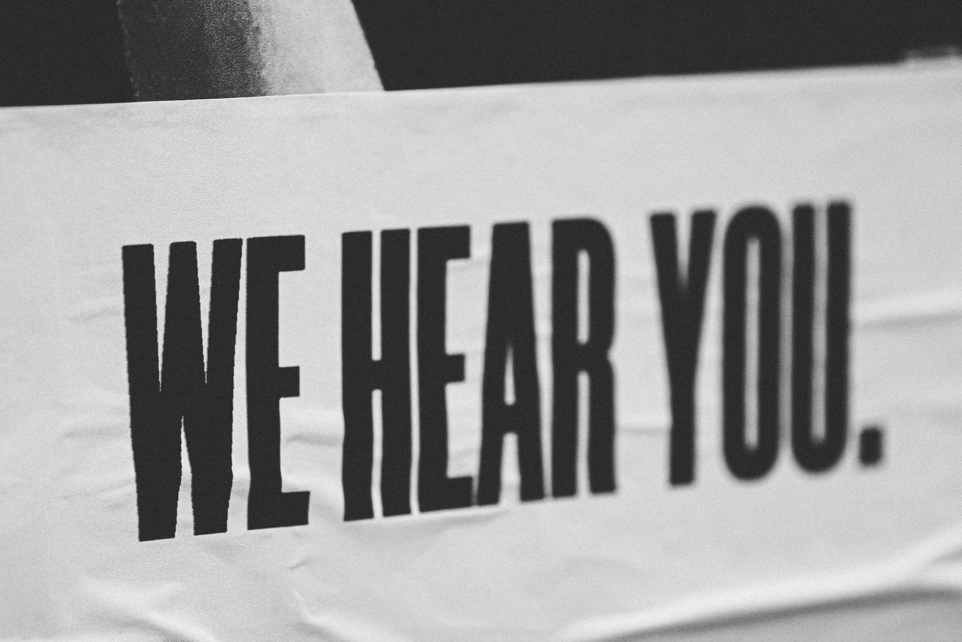 Paper banner with the word "We Hear You", as this is the real estate services page, it makes sense that we're going to listen to you.